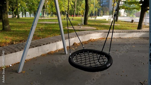 Round shape swings in empty city park on sunny autumn day. Lockout concept. 