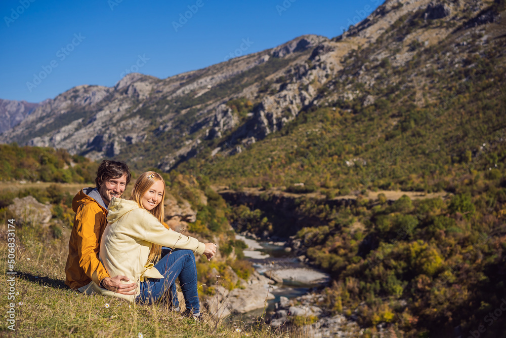 Montenegro. Happy couple man and woman tourists on the background of Clean clear turquoise water of river Moraca in green moraca canyon nature landscape. Travel around Montenegro concept