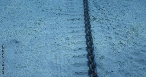 anchor chain at the bottom of sea on sand moving ocean scenery underwater photo