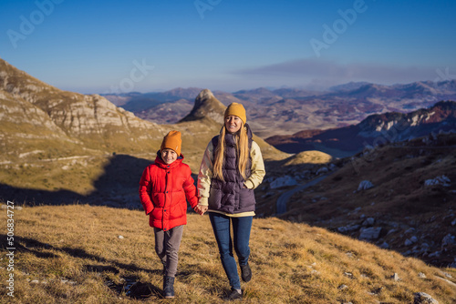 Montenegro. Mom and son tourists in the background of Durmitor National Park. Saddle Pass. Alpine meadows. Mountain landscape. Travel around Montenegro concept