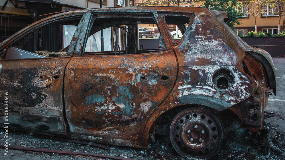 Irpin, Kyiv Oblast, Ukraine - 19.05.2022: Cities of Ukraine after the Russian occupation. burnt civilian car in city of Irpin, northwest of Kyiv