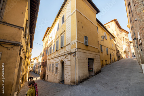 Fototapeta Naklejka Na Ścianę i Meble -  View on narrow and cozy street in the old town of Siena city in Italy. Concept of ancient architecture of the Tuscan region