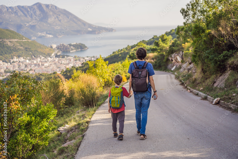 Happy family on the background of Panoramic view of the city of Budva, Montenegro. Beautiful view from the mountains to the Adriatic Sea Happy family on the background of Panoramic view of the city of Budva, Montenegro. Beautiful view from the mountains to the Adriatic Sea
