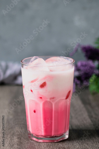 cold pink milk cold drink in clear glass on gray background. Thai milk