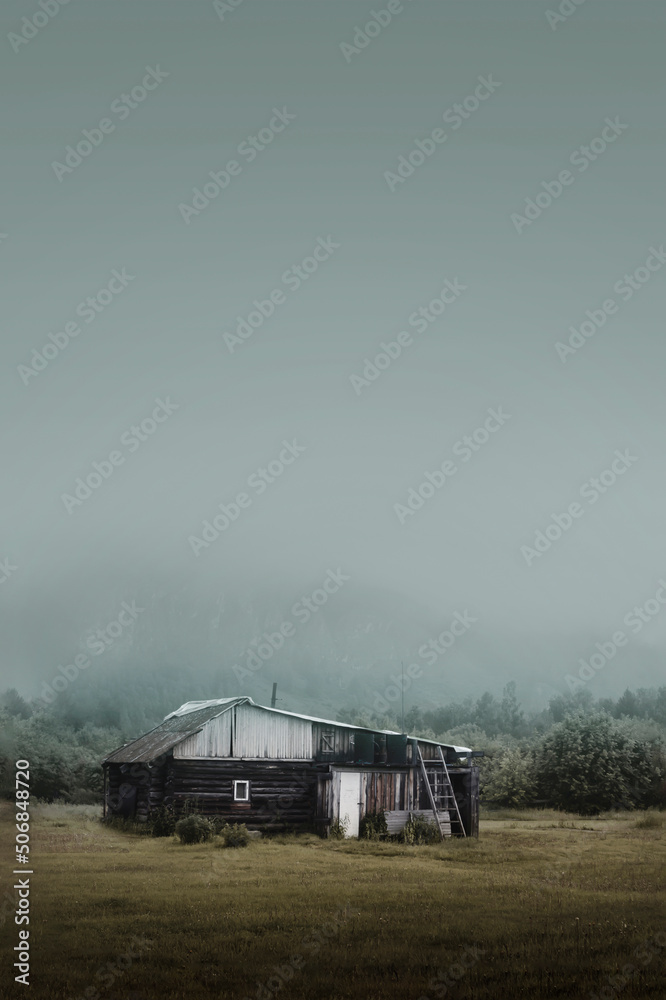 rural simple house in the forest in the morning at the foot of the mountain in a thick fog, gloomy disturbing landscape copy space copyspace
