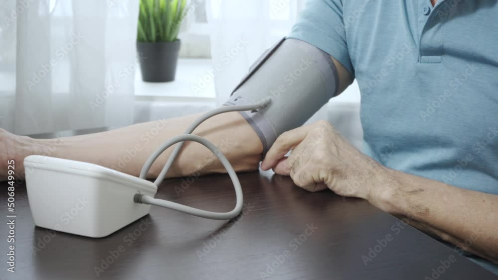 Elderly man measures his own blood pressure with a tonometer Elderly man measures his own blood pressure with a tonometer