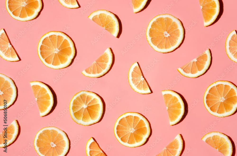 Fototapeta premium Pattern of many sliced lemons and oranges on a trendy bright pink background. Flat lay, top view. Summer freshness, detox, antioxidants, healthy lifestyle concept