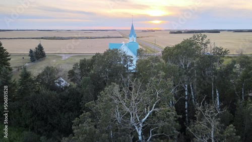 A beautiful old wooden church in rural Alberta at sunset. Aerial HDR approaching shot photo