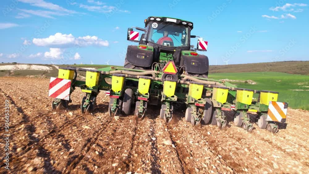 Agricultural tractor sowing and cultivating field. High quality 4k footage