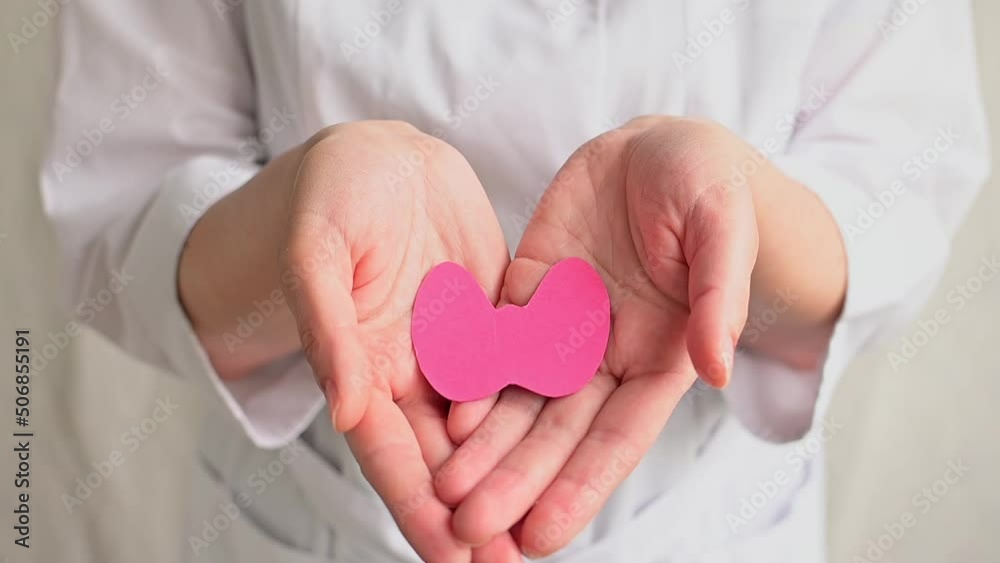World Thyroid Day. Doctor in coat holds paper form of the thyroid gland. Problems with thyroid. Polycystic disease. World cancer day World Thyroid Day. Doctor in coat holds paper form of the thyroid gland. Problems with thyroid. Polycystic disease. World cancer day