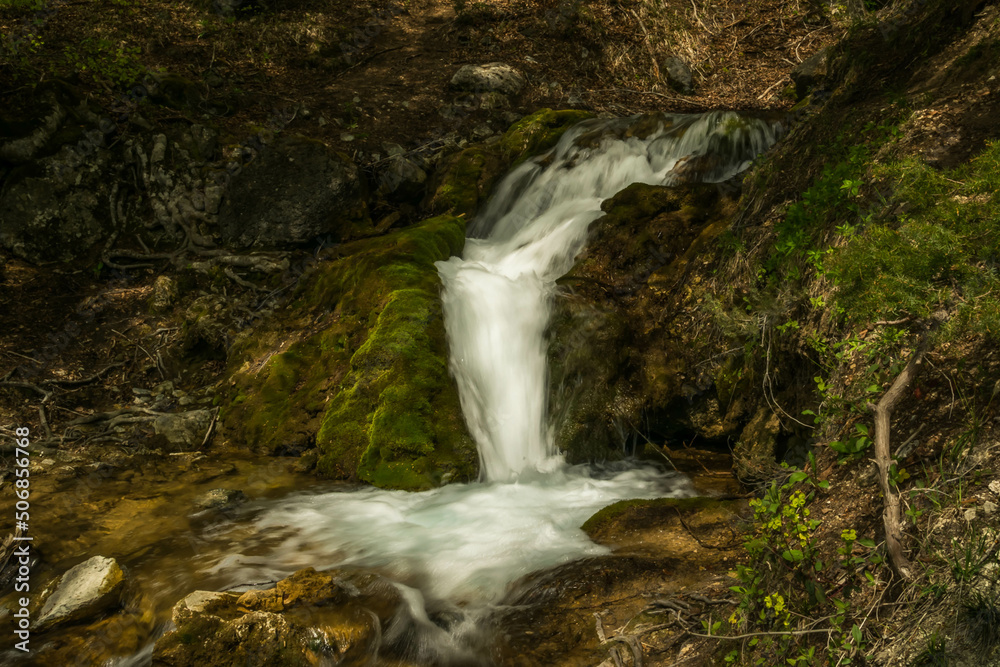 waterfall in the mountains with moss and rocks around waterfall in the mountains with moss and rocks around