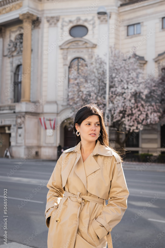 stylish woman in elegant coat standing on street in vienna.