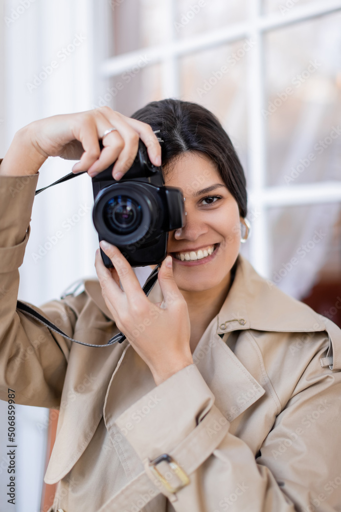 happy photographer in trench coat taking photo on digital camera. happy photographer in trench coat taking photo on digital camera.