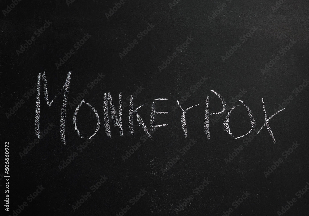 Obraz premium The word Monkeypox is written in white chalk on a black board. There is an outbreak of monkeypox in the world. A new global epidemic.