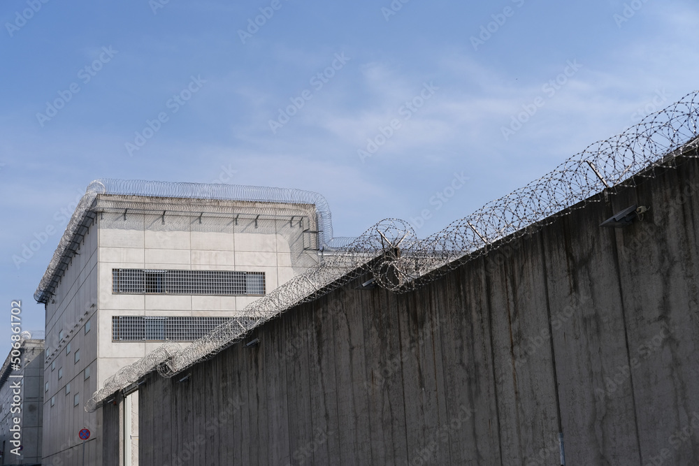 high concrete fence, barbed wire fence on top, pre-trial detention cell, building for execution of punishments for criminals, concept prison, security zone, hopelessness of captivity