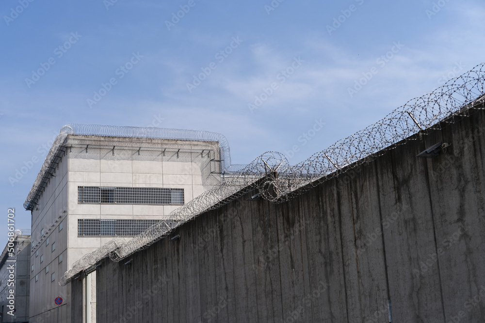 high concrete fence, barbed wire fence on top, pre-trial detention cell, building for execution of punishments for criminals, concept prison, security zone, hopelessness of captivity high concrete fence, barbed wire fence on top, pre-trial detention cell, building for execution of punishments for criminals, concept prison, security zone, hopelessness of captivity