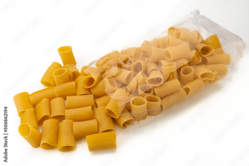 Paccheri pasta coming out of transparent bag isolated on white, typical Italian macaroni from Gragnano Paccheri pasta coming out of transparent bag isolated on white, typical Italian macaroni from Gragnano