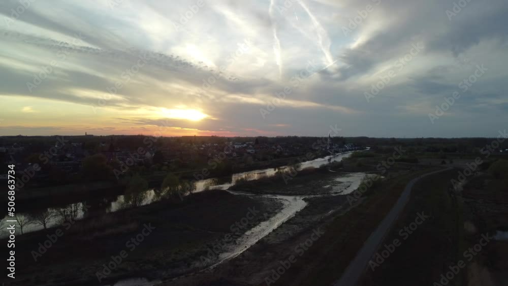 Aerial view approaching river and small town during sunset Aerial view approaching river and small town during sunset