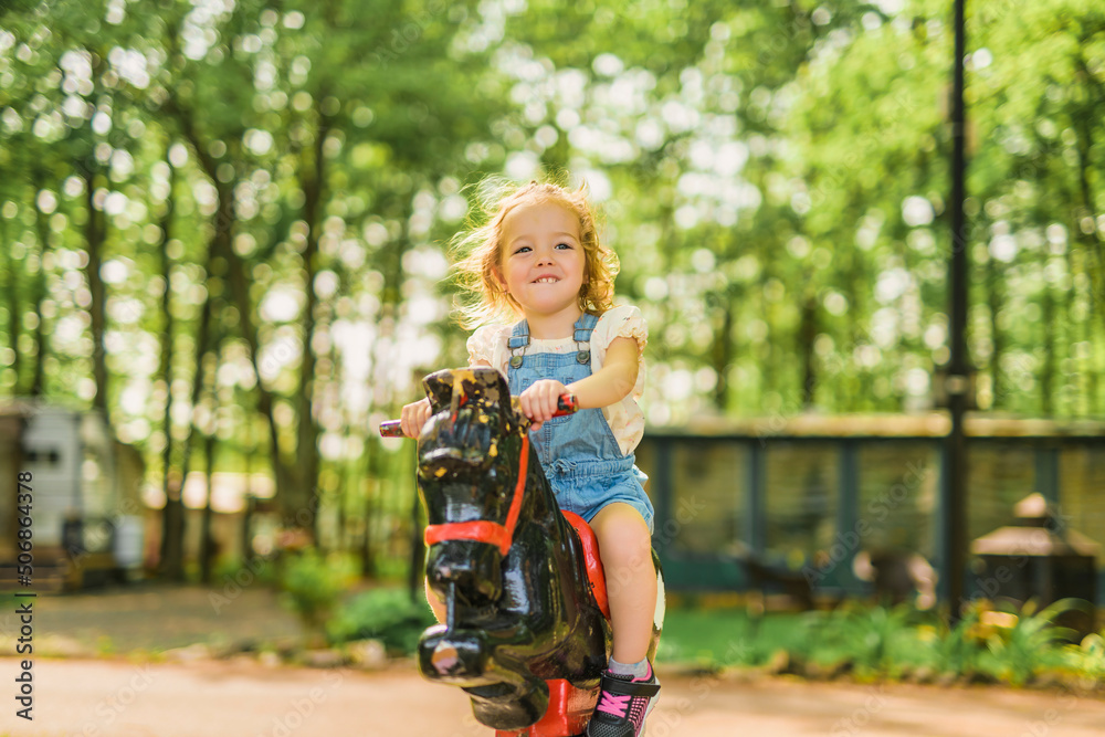 Child playing on outdoor playground. Active kid on playground summer activity for children Child playing on outdoor playground. Active kid on playground summer activity for children