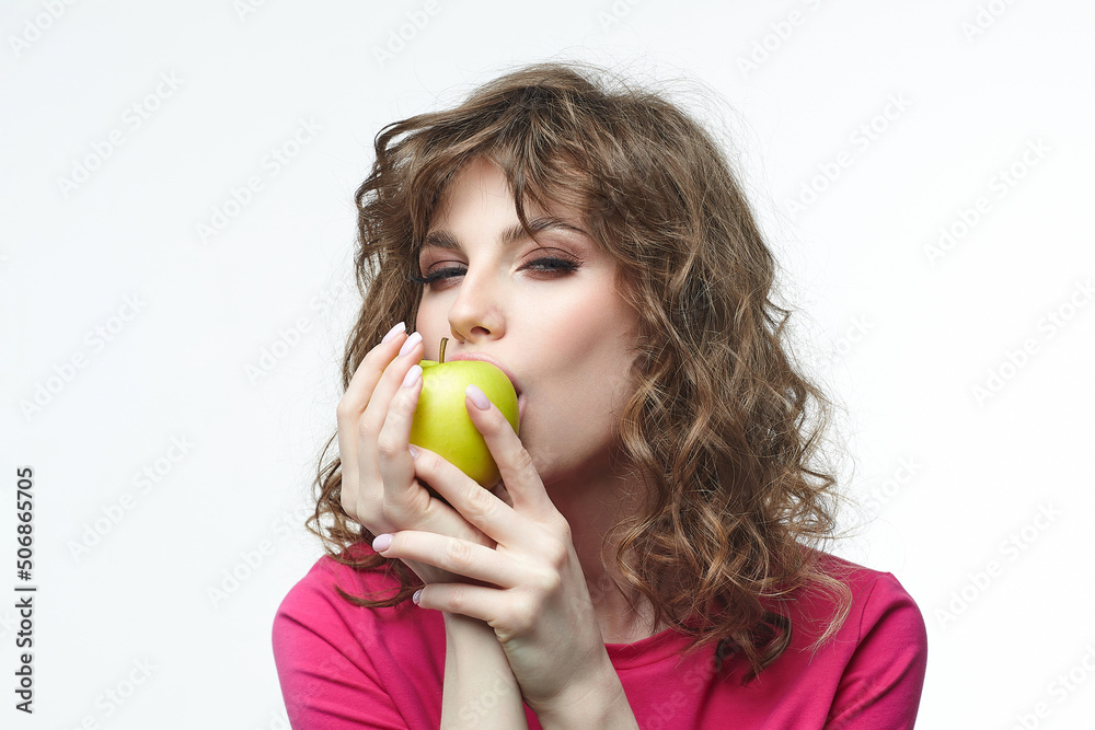 attractive girl is going to bite off a ripe green apple. attractive girl is going to bite off a ripe green apple.