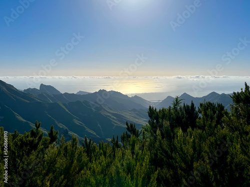 sunrise in the mountains with clouds over the ocean