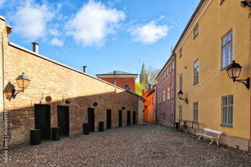 Medieval narrow alley in Turku, Finland called Luostarin välikatu. It used to lead from the monastery to the city centre and the cathedral visible in the background.