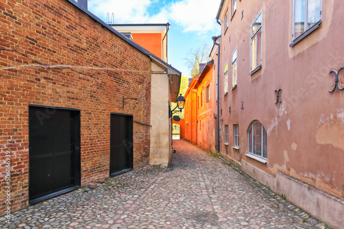 Medieval narrow alley in Turku  Finland called Luostarin v  likatu. It used to lead from the monastery to the city centre and the cathedral visible in the background.