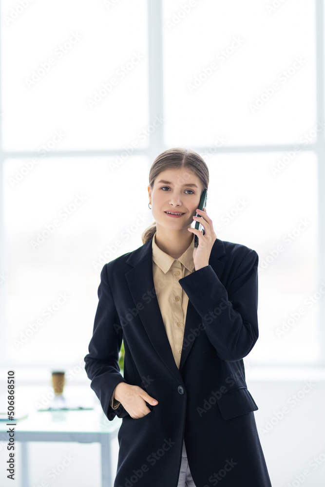 Young business woman working in office talking on a cell phone Young business woman working in office talking on a cell phone