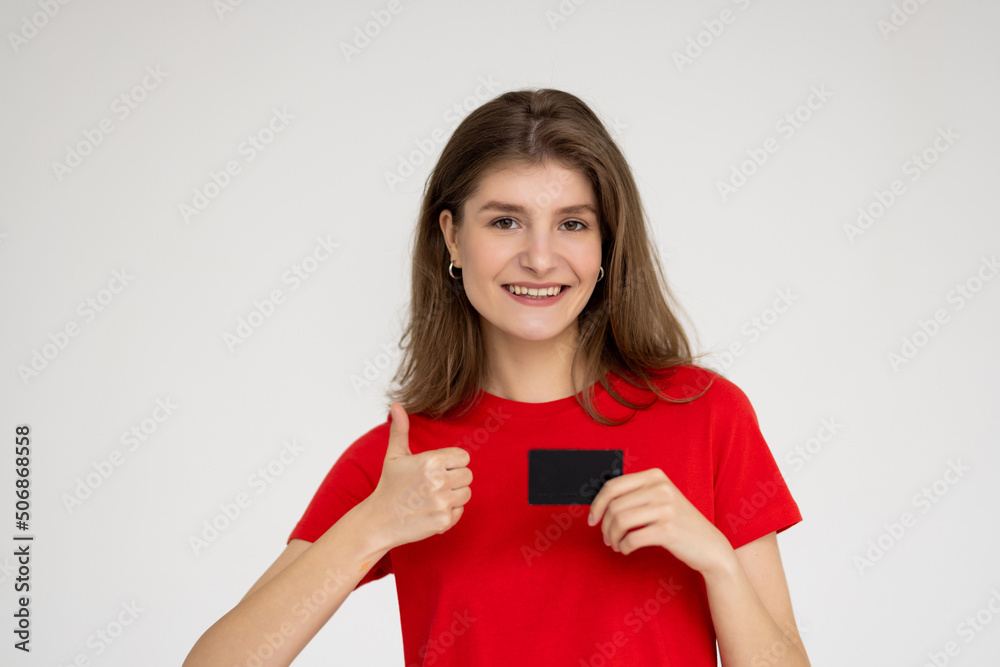 Young woman with credit card showing thumb-up gesture on white background. Online shopping Young woman with credit card showing thumb-up gesture on white background. Online shopping