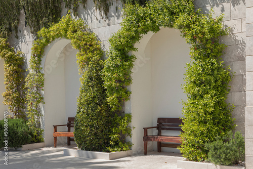Archways of white coloured stone with benches Fototapet