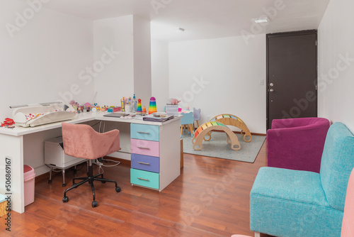 Pediatric office with colored chairs for waiting patients, and pediatric equipment photo
