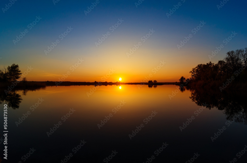 Beautiful sunset over the lake. Dust Beautiful sunset over the lake. Dust