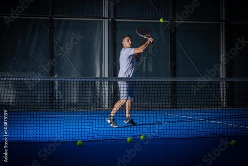 Man playing padel tennis indoor
