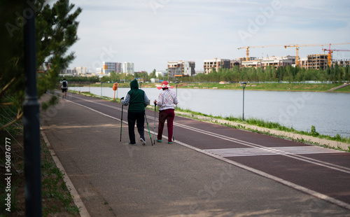 Wallpaper Mural Two elderly women are engaged in Nordic walking on the waterfront. High quality photo Torontodigital.ca