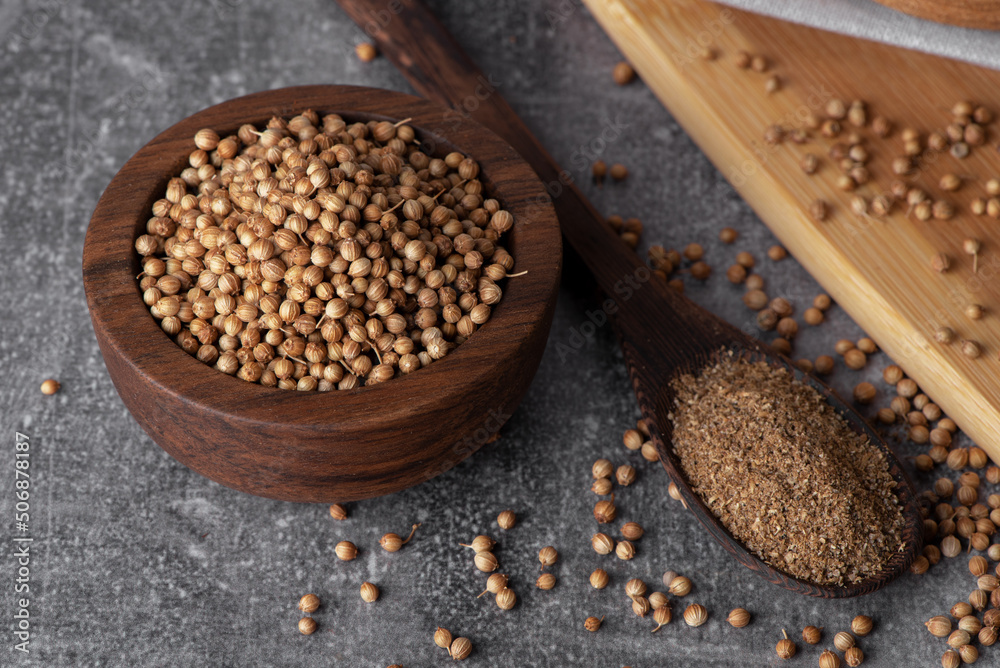 Coriander powder and coriander beans in a wooden spoon. Dry coriander. Coriander seed spice. Coriander powder and coriander beans in a wooden spoon. Dry coriander. Coriander seed spice.