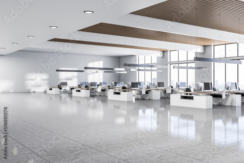 Perspective view on sunny spacious coworking office with modern work places and computers, metallic lamps hanging from wooden ceiling, white walls, glossy ceramic floor and city view. 3D rendering