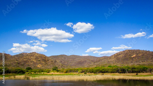 a beautiful landscape, lake to the mountain feet, with blue sky background