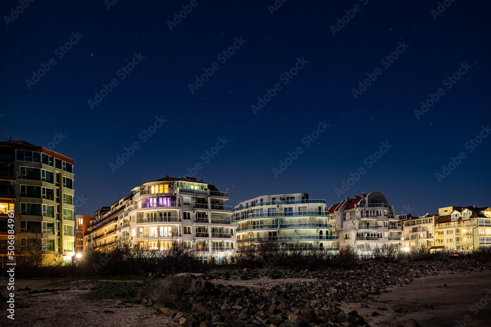 Pomorie town with lights and hotels against the backdrop of the night sky and the Black Sea in Bulgaria