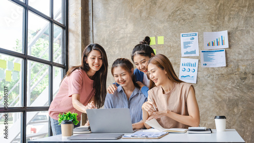 Картината върху платно Asian female team of four business people meeting in office and looking to laptop computer, smile and feeling happy