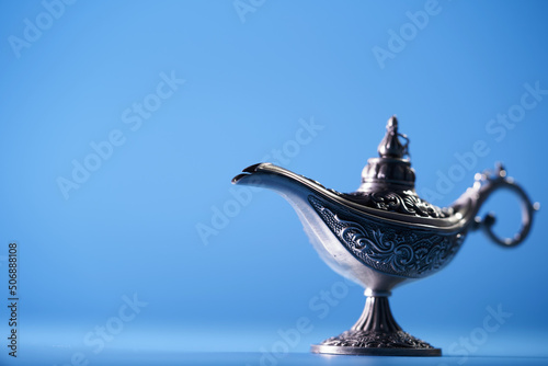 close up alladin magic lamp against blue background