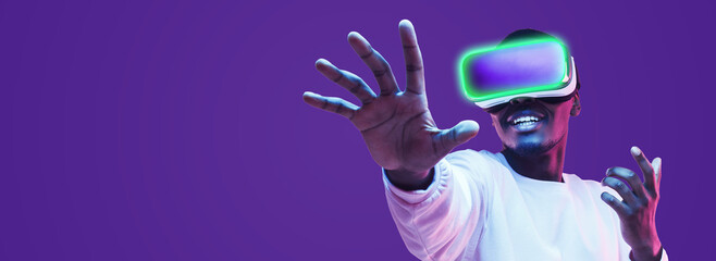 Banner of black man in vr headset exploring metaverse world, touching virtual reality subjects