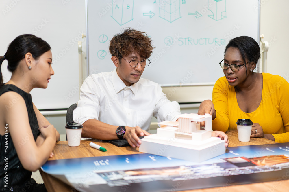 Fototapeta premium Group of diversity architect designer discuss and critic architecture design project in the office. man presenting and explaining house model to client. team brainstorming for work process