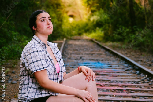 Teenager staring into infinity on some abandoned train tracks. © Sergi