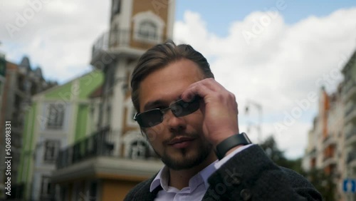 Young bearded man removing sunglasses and sensibly staring into the soul of the viewer. millennial separating fake mask and showing true emotions hidden behind a facade. Deep look directly into camera