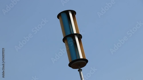 Vertical axis Wind generator or a wind turbine in working condition on a day with blue sky in the background photo