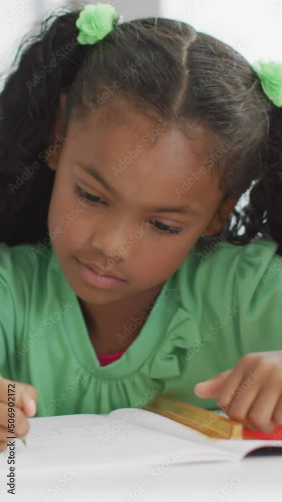 Video of african american girl sitting at desk during lesson in classroom Video of african american girl sitting at desk during lesson in classroom