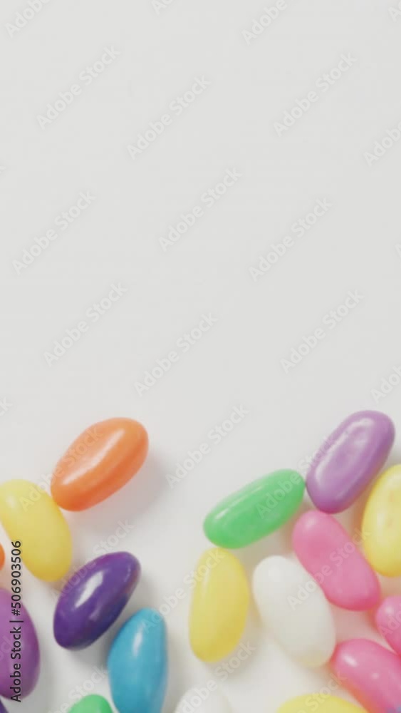 Video of overhead view of multi coloured sweets with copy space over white background Video of overhead view of multi coloured sweets with copy space over white background