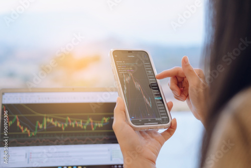 Woman is checking Bitcoin price chart on digital exchange on smartphone, cryptocurrency future price action prediction. photo