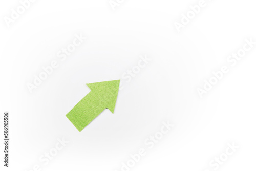 Right-up arrow cutted from solid sheet of green color felt and curved up of one side with white paper underlay showing growth of stock market or up direction