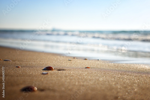Sea waves and warm sunset light, calm and relaxing sandy beach